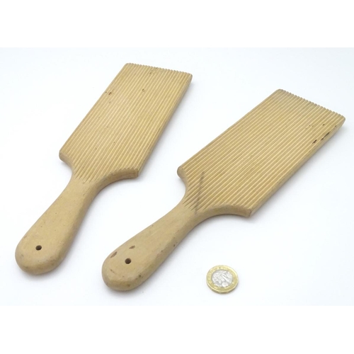 223 - A pair of late 19th / early 20thC carved beech butter pats, each 11'' long.