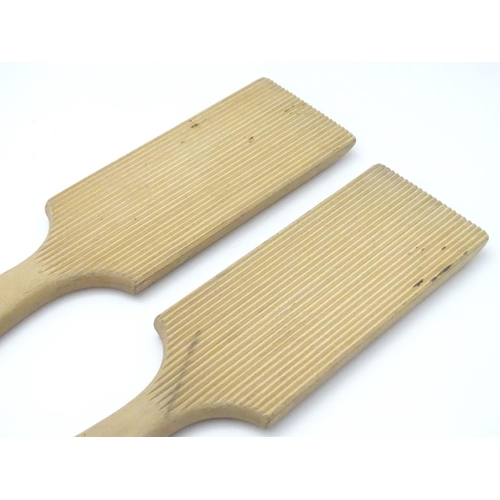 223 - A pair of late 19th / early 20thC carved beech butter pats, each 11'' long.