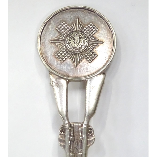 239 - A white metal spoon, the stem formed as two rifles with guards emblem