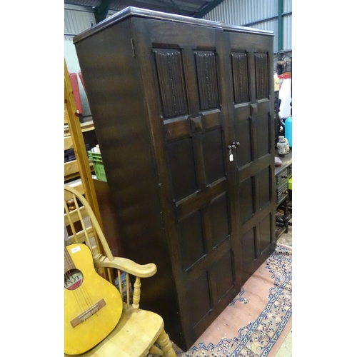283 - A large double wardrobe with linen fold decoration by Skull Furniture