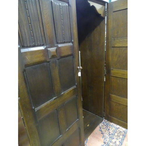 283 - A large double wardrobe with linen fold decoration by Skull Furniture