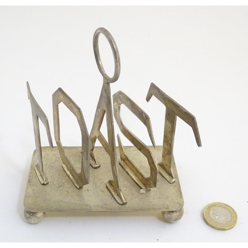 357 - A 21stC silver plated toast rack, the divisions formed as the letters 'TOAST'. 4 1/4'' long, 5'' tal... 