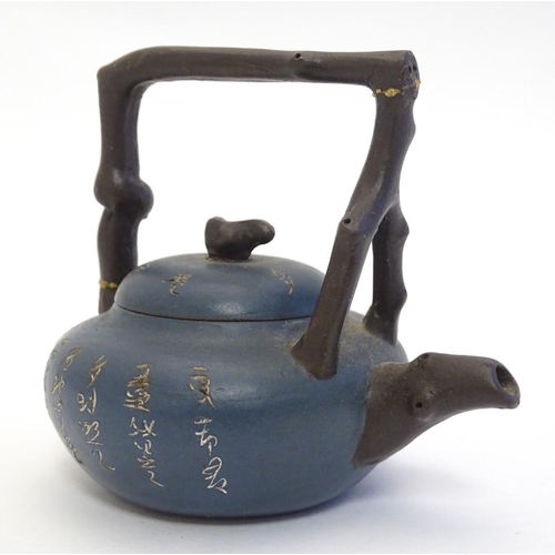 10A - A small Chinese Yixing earthenware / clay teapot and cover with a blue ground, the handle modelled a... 