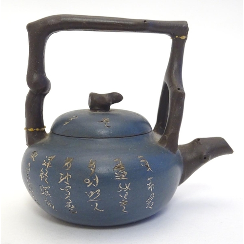 10A - A small Chinese Yixing earthenware / clay teapot and cover with a blue ground, the handle modelled a... 