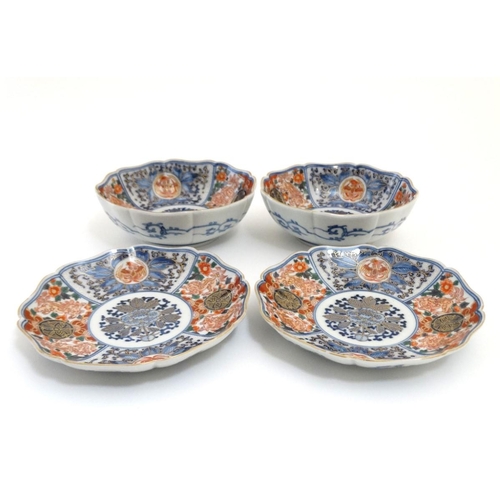 15 - A pair of Japanese Imari plates and matching pair of bowls, having decorative floral and foliate pan... 