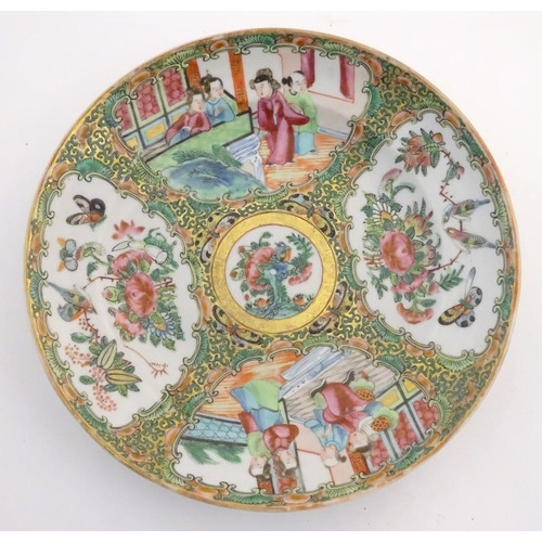 23 - A Chinese Cantonese famille rose plate with panelled decoration depicting figures in an interior and... 