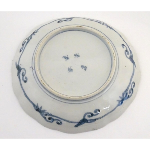 24 - A Chinese plate with a lobed rim, decorated with a landscape with stylised quail birds. Scrolling fo... 