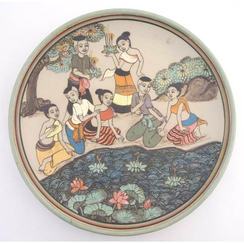 29 - An Oriental plate, the unglazed centre decorated with a group of people in a landscape relaxing near... 