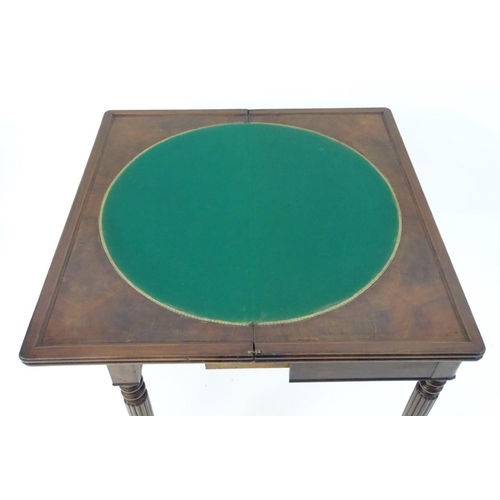 1102 - A late Georgian mahogany folding card table, having a moulded rectangular top above four reeded tape... 
