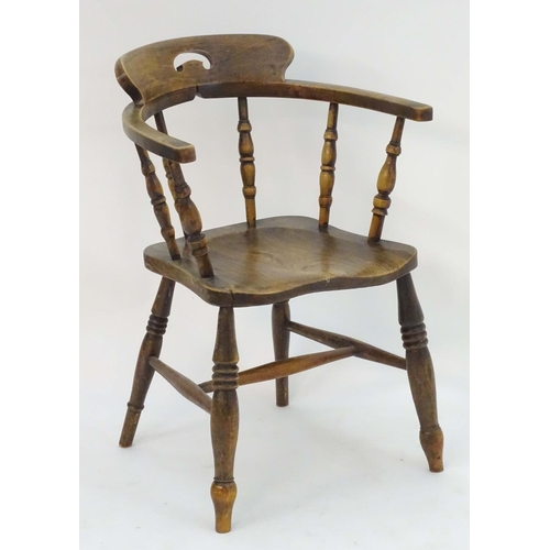1173 - A 19thC smokers bow chair with a pierced top rail, curved backrest with turned supports above an elm... 