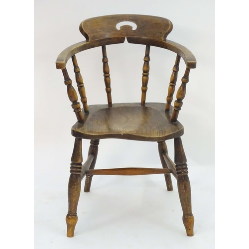 1173 - A 19thC smokers bow chair with a pierced top rail, curved backrest with turned supports above an elm... 
