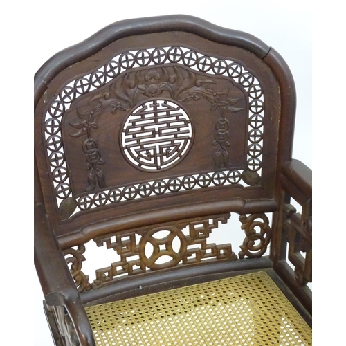 1174 - A pair of Chinese hardwood armchairs with pierced and carved backrests, fretwork supports and caned ... 