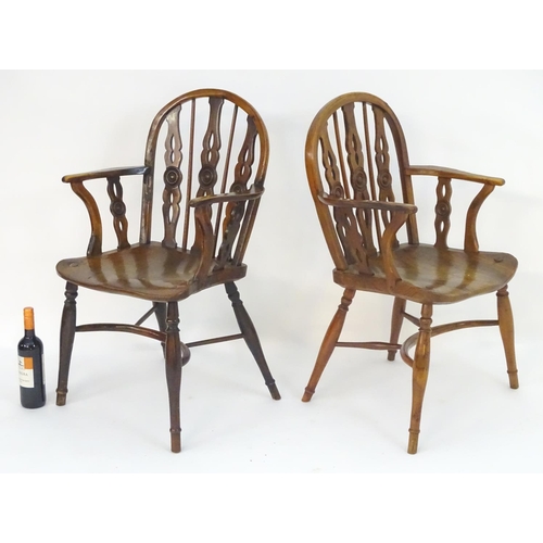 1020 - Two early / mid 19thC yew wood draught back Windsor chairs, with bowed backs and three carved back s... 