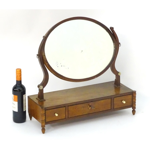 1022 - An early 19thC mahogany dressing table mirror, with an oval frame above three short drawers and rais... 