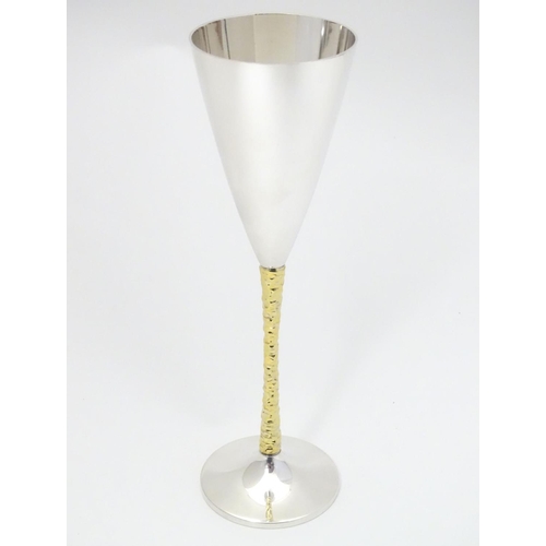 227 - An Elizabeth II silver gilt Stuart Devlin champagne flute having flaring conical body with textured ... 