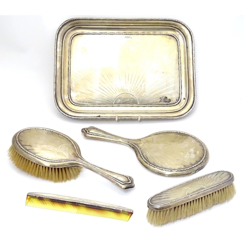 298 - An Art Deco silver dressing table set comprising tray, brushes and com with engine turned radiating ... 