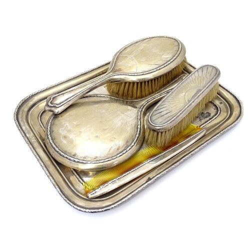 298 - An Art Deco silver dressing table set comprising tray, brushes and com with engine turned radiating ... 