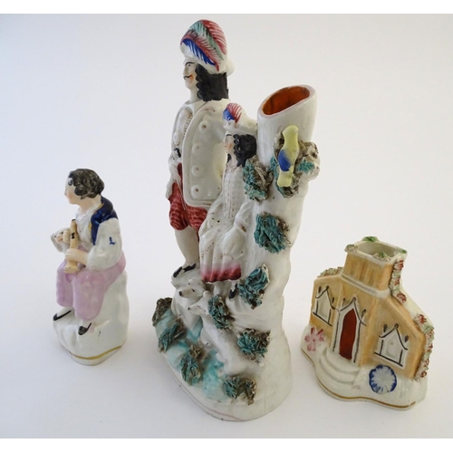 28 - Three items of Staffordshire pottery, to include a figural bud vase, a flatback house and a figure w... 