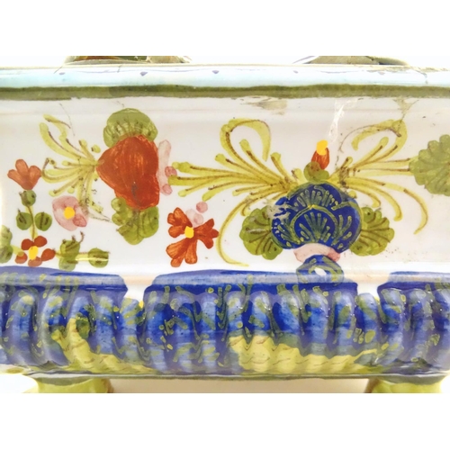 72 - A Continental faience inkwell of sarcophagus form  on four paw feet with hand painted floral decorat... 