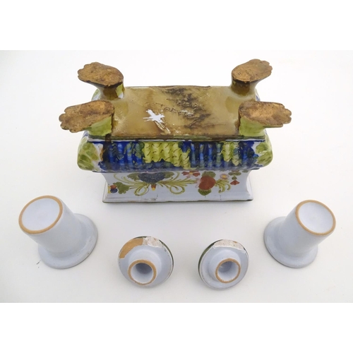 72 - A Continental faience inkwell of sarcophagus form  on four paw feet with hand painted floral decorat... 