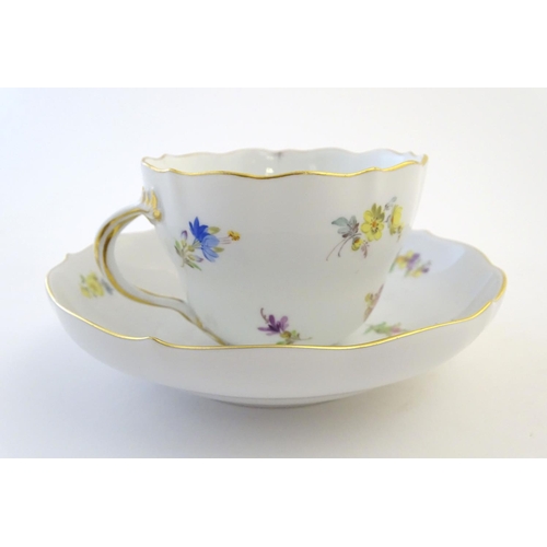 105 - A 19thC Meissen cup and saucer decorated with flowers and gilt highlights. Meissen marks under cup a... 