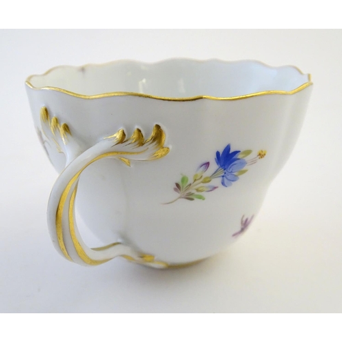 105 - A 19thC Meissen cup and saucer decorated with flowers and gilt highlights. Meissen marks under cup a... 