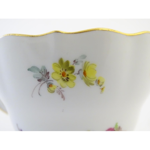 105 - A 19thC Meissen cup and saucer decorated with flowers and gilt highlights. Meissen marks under cup a... 