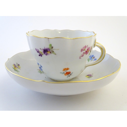 105 - A 19thC Meissen cup and saucer decorated with flowers and gilt highlights. Meissen marks under cup a... 