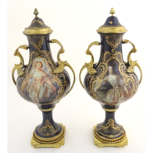 131 - A matched pair of Sevres style lidded urn garnitures on mounted bases, with cobalt blue bodies with ... 