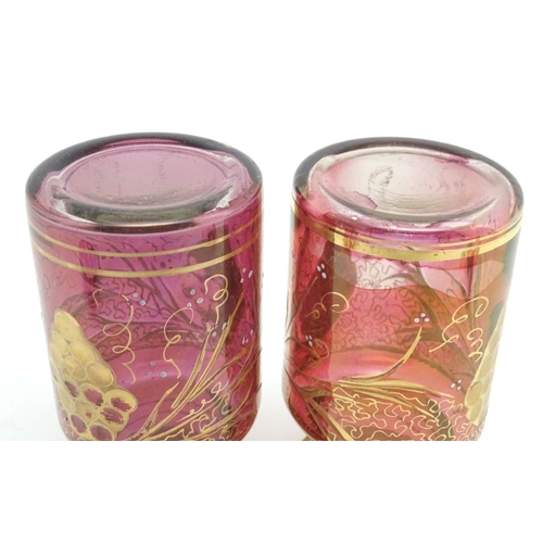 141 - A pair of 19thC cranberry glass jars, each decorated with hand painted vines and bands. 7 1/2