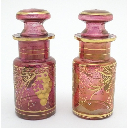 141 - A pair of 19thC cranberry glass jars, each decorated with hand painted vines and bands. 7 1/2