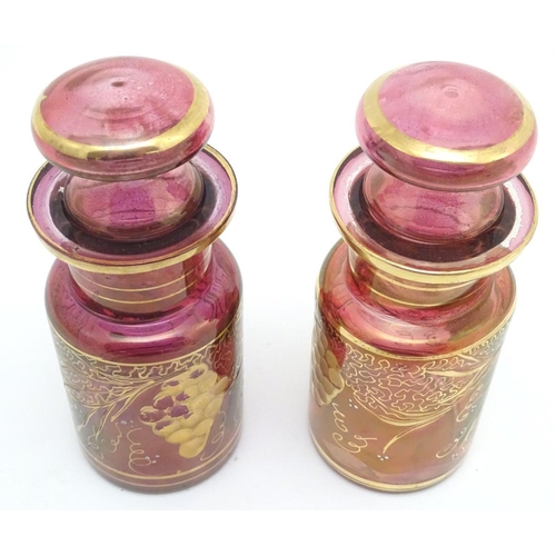 141 - A pair of 19thC cranberry glass jars, each decorated with hand painted vines and bands. 7 1/2