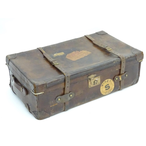 856 - A late 19thC leather travelling trunk flanked by carrying handles. 34