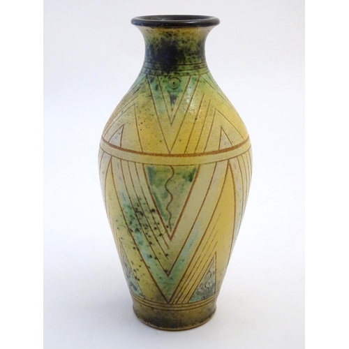 103 - A 20thC studio pottery baluster vase with incised geometric decoration. Impressed G maker's mark und... 