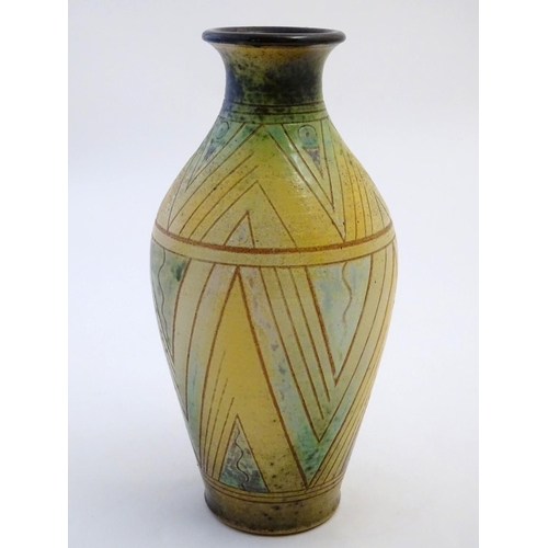 103 - A 20thC studio pottery baluster vase with incised geometric decoration. Impressed G maker's mark und... 