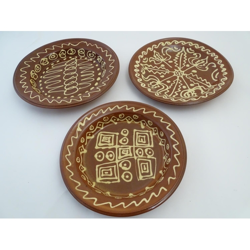 109 - Three 20thC slipware chargers decorated with abstract patterns. One with impressed H maker's mark. L... 