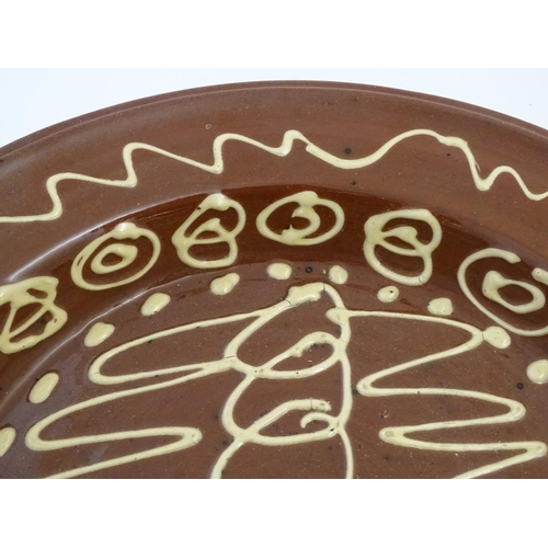 109 - Three 20thC slipware chargers decorated with abstract patterns. One with impressed H maker's mark. L... 