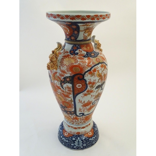 115 - A large Oriental baluster vase with a flared rim and twin handles formed as stylised clouds. Decorat... 