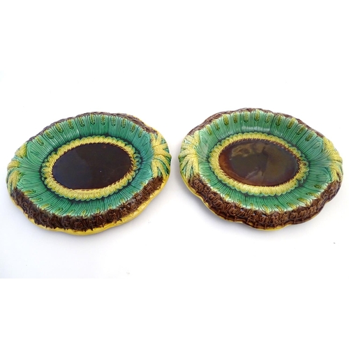 117 - A pair of Victorian majolica bread plates, the inner rim decorated with wheat sheaves, the outer edg... 