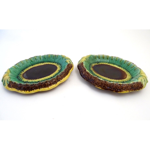 117 - A pair of Victorian majolica bread plates, the inner rim decorated with wheat sheaves, the outer edg... 