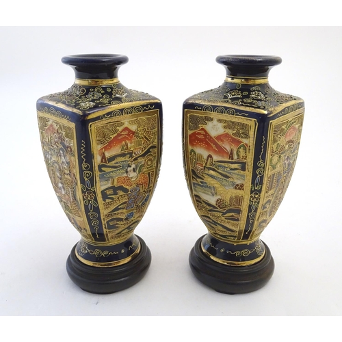 124 - A pair of Japanese Satsuma vases of square baluster form with a cobalt blue ground, with panelled de... 