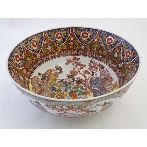 126 - A large Japanese bowl with hand painted decoration the central roundel depicting figures / geisha gi... 