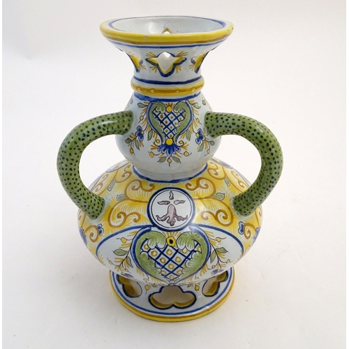 135 - A Continental faience double gourd vase with three loop handles, reticulated openwork to rim and bas... 