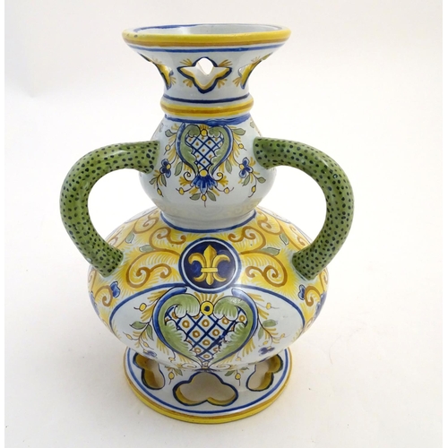 135 - A Continental faience double gourd vase with three loop handles, reticulated openwork to rim and bas... 