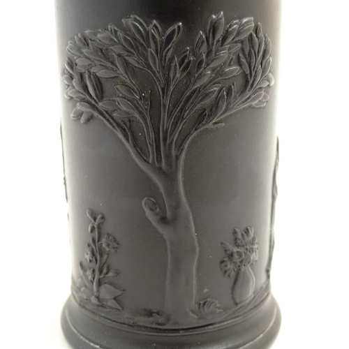 56 - A Wedgwood basalt ware cylindrical vase with classical decoration depicting Apollo in a landscape. I... 