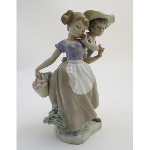 79 - A Lladro figural group depicting a girl and boy with flowers, Love in Bloom, model no. 5292. Approx.... 