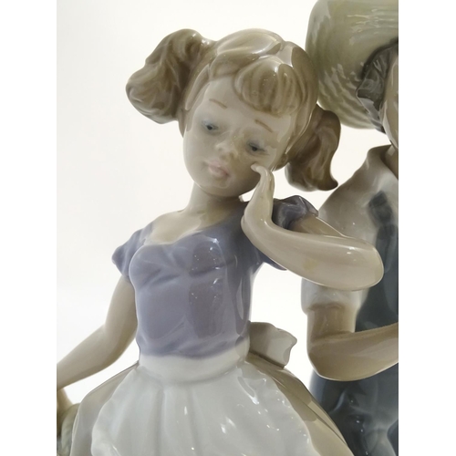 79 - A Lladro figural group depicting a girl and boy with flowers, Love in Bloom, model no. 5292. Approx.... 