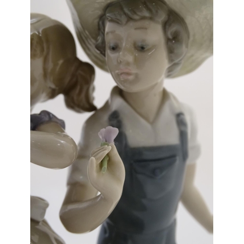 79 - A Lladro figural group depicting a girl and boy with flowers, Love in Bloom, model no. 5292. Approx.... 