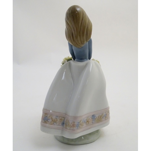 80 - A Lladro figure of a girl with a basket of flowers, May Flowers Girl, model no. 5467. Marked under. ... 