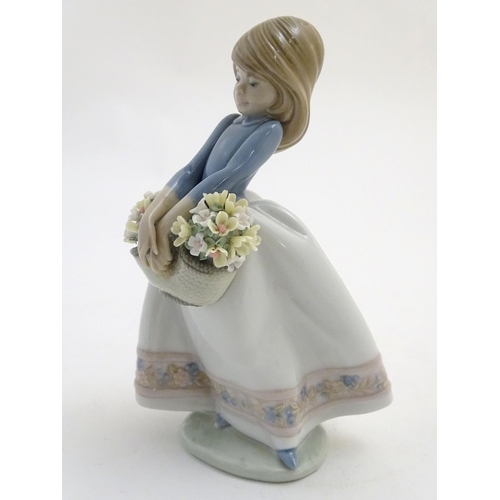 80 - A Lladro figure of a girl with a basket of flowers, May Flowers Girl, model no. 5467. Marked under. ... 